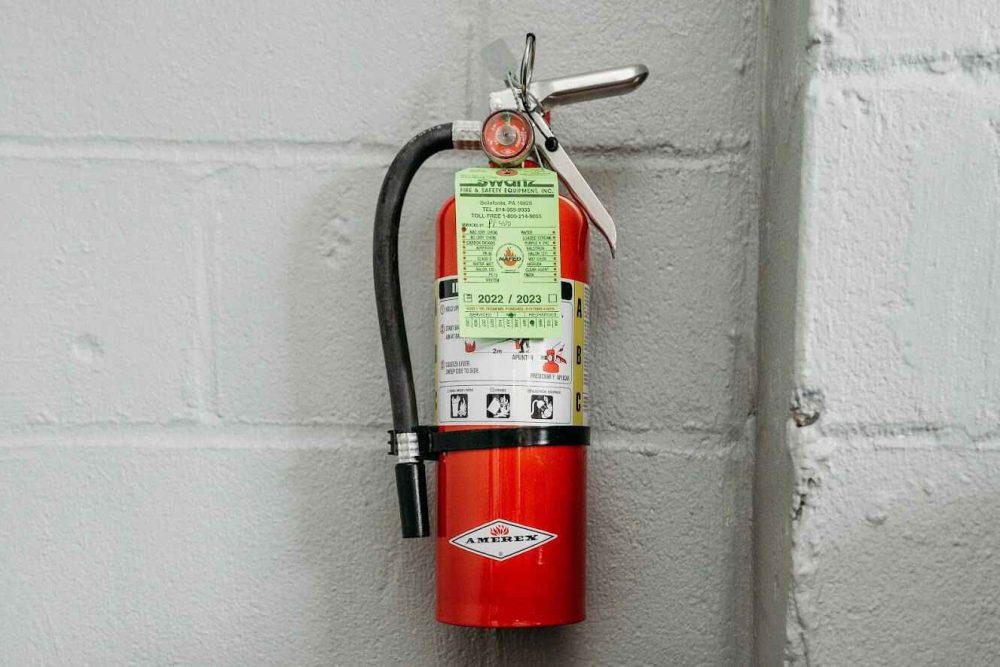 An ABC fire extinguisher hanging on a wall_11zon